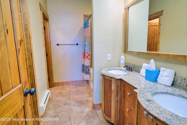 bathroom with a baseboard heating unit, tile patterned flooring, a sink, and double vanity