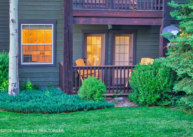 view of exterior entry with a lawn