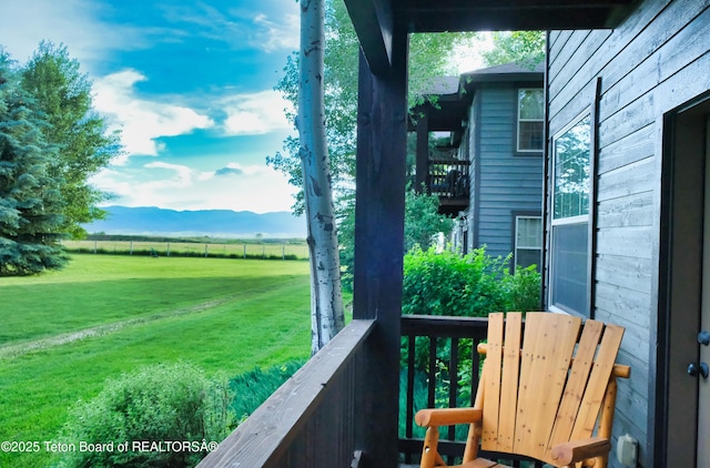 balcony featuring a rural view and a mountain view