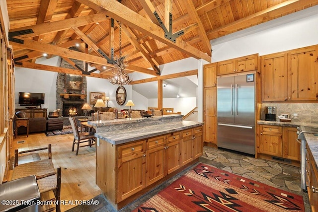 3102 W Arrowhead Rd, Teton Village, WY 83025 - kitchen with stainless steel built in refrigerator, open floor plan, a wood ceiling with exposed beams, stone countertops, and a center island