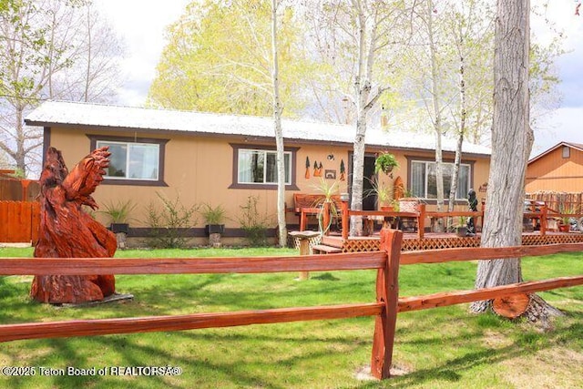 single story home with fence, a front lawn, and a wooden deck