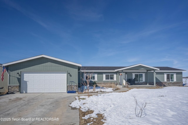 ranch-style house with a garage, stone siding, and driveway