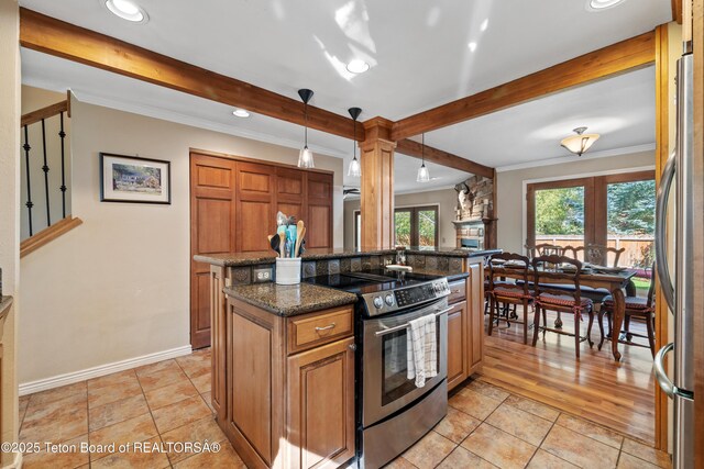 kitchen featuring beam ceiling, plenty of natural light, and appliances with stainless steel finishes