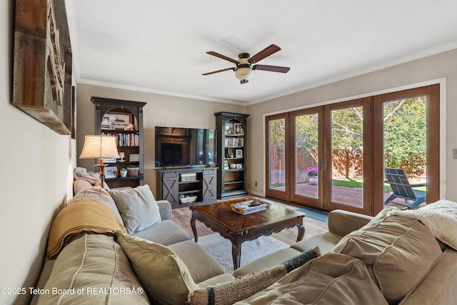 living area with plenty of natural light, crown molding, a ceiling fan, and wood finished floors