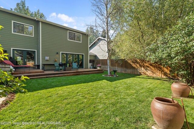 back of house with a lawn, a deck, and fence