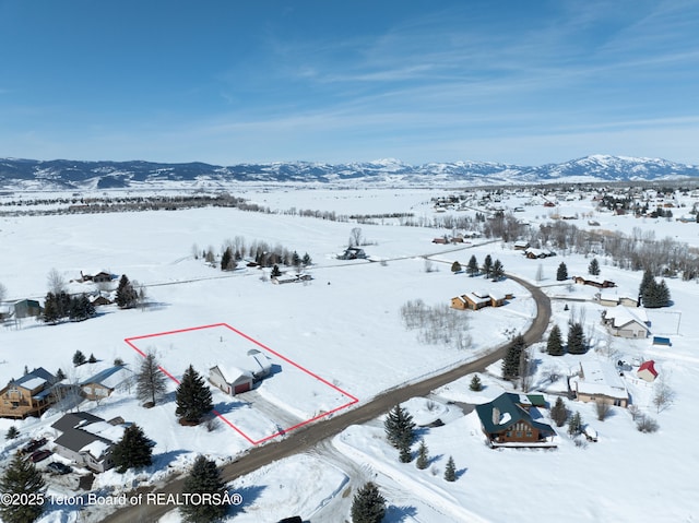 snowy aerial view featuring a mountain view