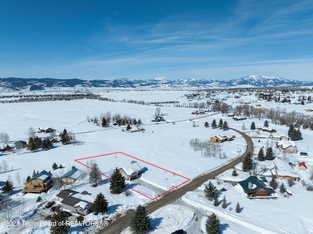 snowy aerial view with a mountain view