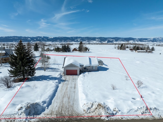 snowy aerial view featuring a mountain view