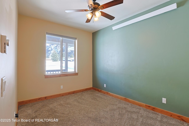 empty room with carpet flooring, a ceiling fan, and baseboards