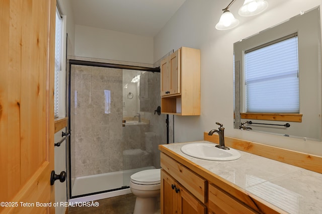 full bathroom with toilet, a stall shower, and vanity