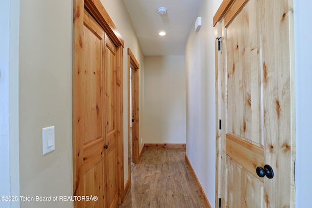 hall featuring wood finished floors and baseboards