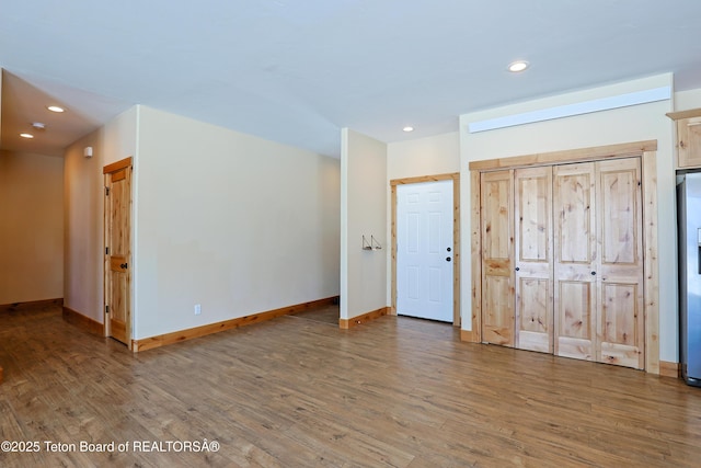 unfurnished bedroom featuring recessed lighting, wood finished floors, and baseboards