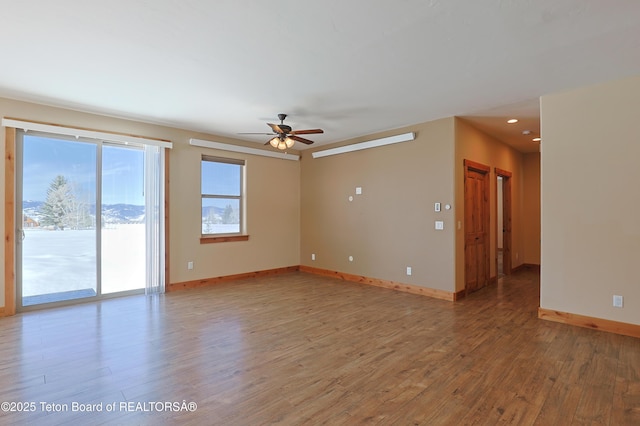 spare room with a ceiling fan, baseboards, and light wood-type flooring