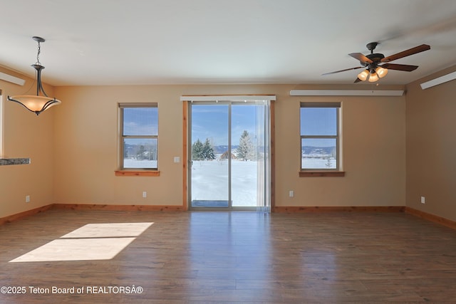 spare room with ceiling fan, baseboards, and wood finished floors