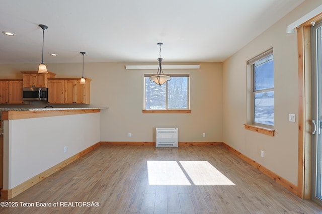 unfurnished dining area with heating unit, recessed lighting, baseboards, and light wood finished floors