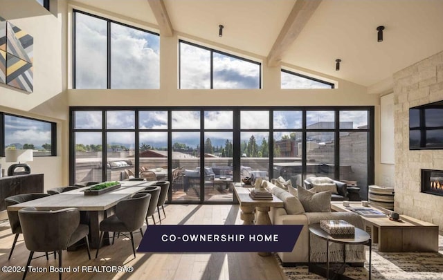 sunroom featuring lofted ceiling with beams and a large fireplace