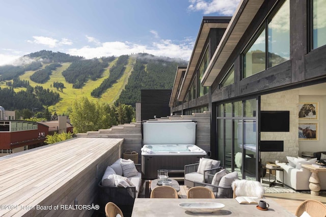 exterior space with a mountain view and a hot tub