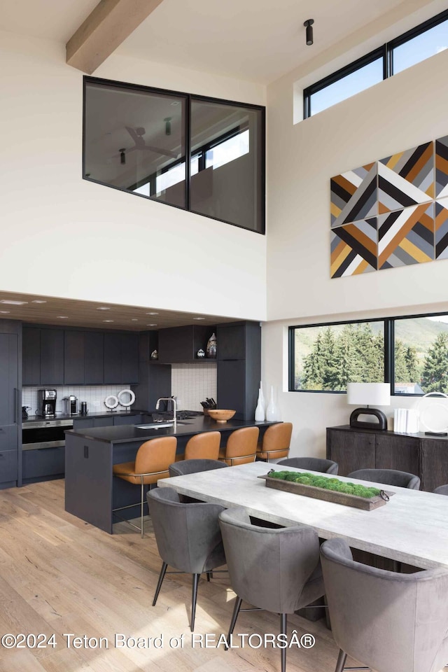 dining area featuring a high ceiling and light wood-type flooring