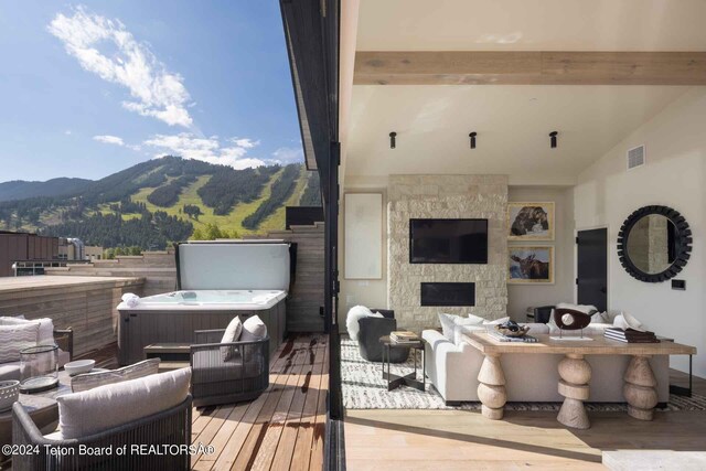 deck with visible vents, a mountain view, and a hot tub