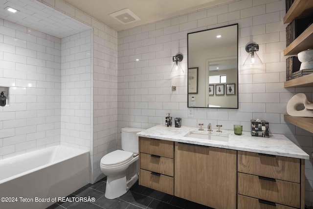 full bathroom featuring tile patterned flooring, tile walls, toilet, and vanity