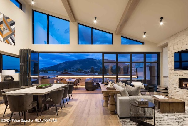 interior space with beamed ceiling, a fireplace, high vaulted ceiling, and hardwood / wood-style flooring