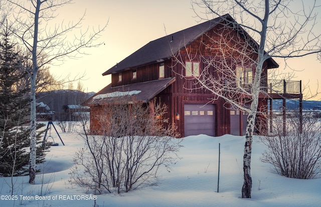 chalet / cabin with board and batten siding and a garage