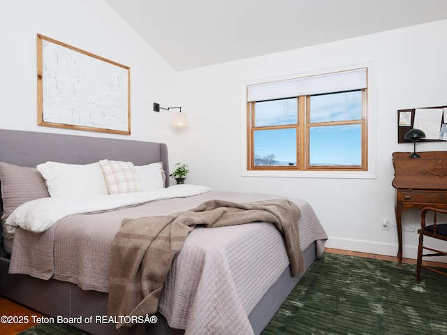 bedroom featuring vaulted ceiling, wood finished floors, and baseboards