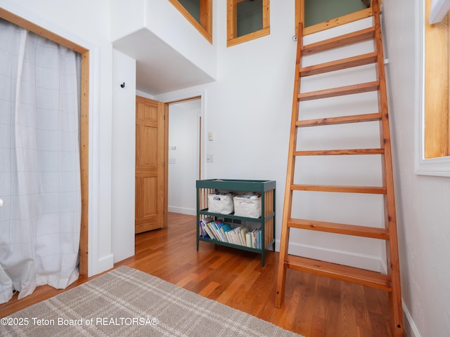 staircase featuring wood finished floors and baseboards