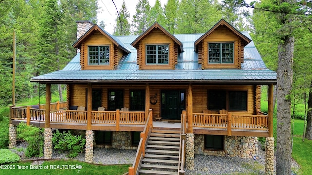 25640 Buffalo Run, Moran, WY 83013 - log home with covered porch, a chimney, log siding, and metal roof