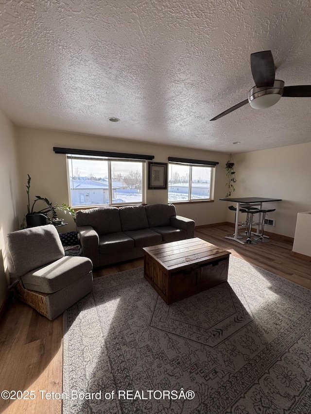 living room featuring a textured ceiling, wood finished floors, and ceiling fan