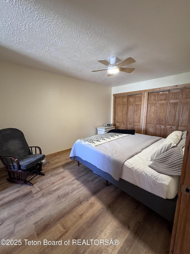 bedroom with a ceiling fan, wood finished floors, and a textured ceiling