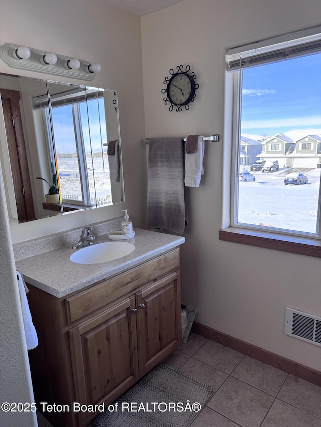 bathroom with visible vents, a healthy amount of sunlight, vanity, and tile patterned flooring