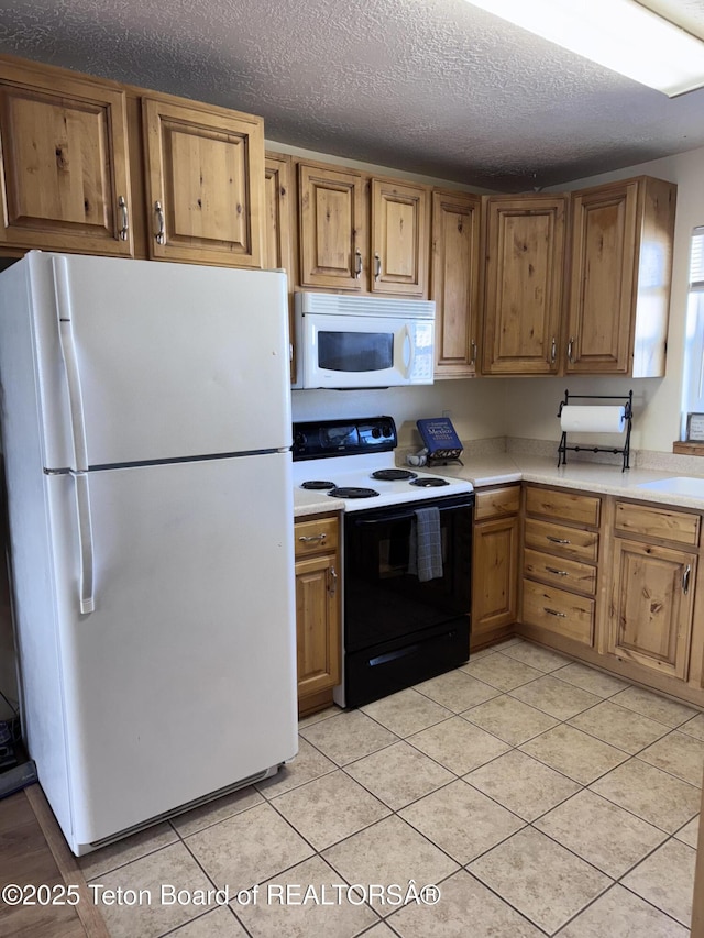 kitchen featuring white appliances, light tile patterned floors, light countertops, a textured ceiling, and brown cabinets