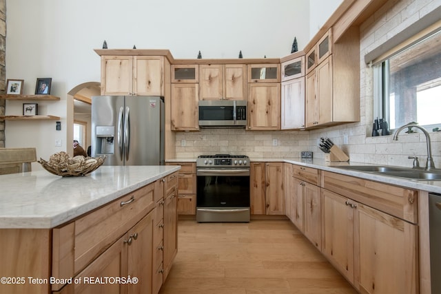 4535 Roxanne St, Tetonia, ID 83452 - kitchen with appliances with stainless steel finishes, a sink, backsplash, arched walkways, and light brown cabinetry