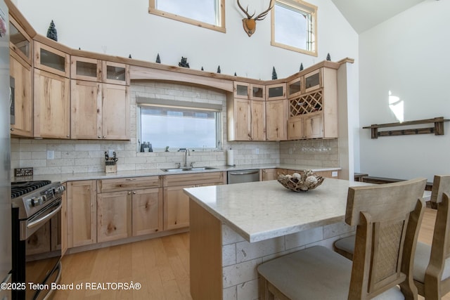 4535 Roxanne St, Tetonia, ID 83452 - kitchen with appliances with stainless steel finishes, a sink, backsplash, light wood finished floors, and a breakfast bar