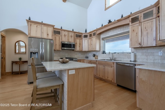 4535 Roxanne St, Tetonia, ID 83452 - kitchen with stainless steel appliances, a sink, high vaulted ceiling, light brown cabinetry, and arched walkways