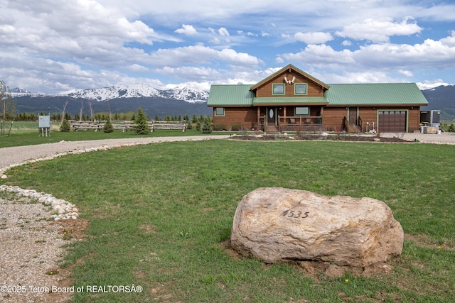 4535 Roxanne St, Tetonia, ID 83452 - cabin featuring covered porch, a mountain view, an attached garage, driveway, and metal roof