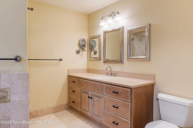 bathroom with tile patterned floors, baseboards, toilet, and vanity