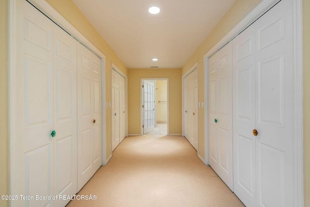 hallway with light carpet, recessed lighting, and baseboards