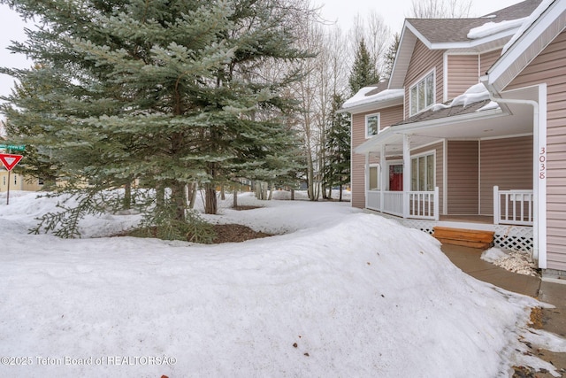 yard layered in snow with a porch