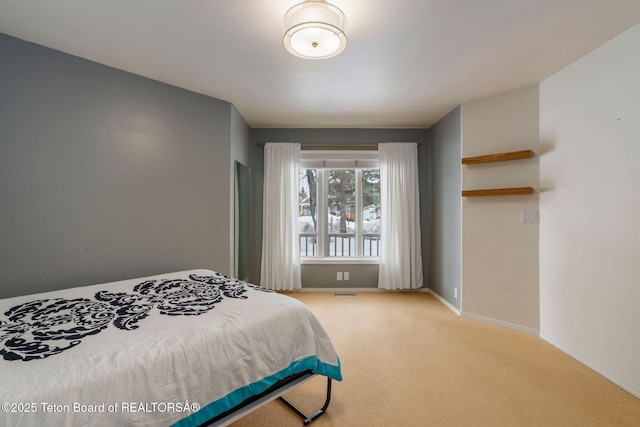 bedroom featuring visible vents, light colored carpet, and baseboards