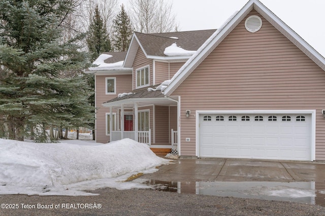 traditional-style house with a garage, a porch, and driveway