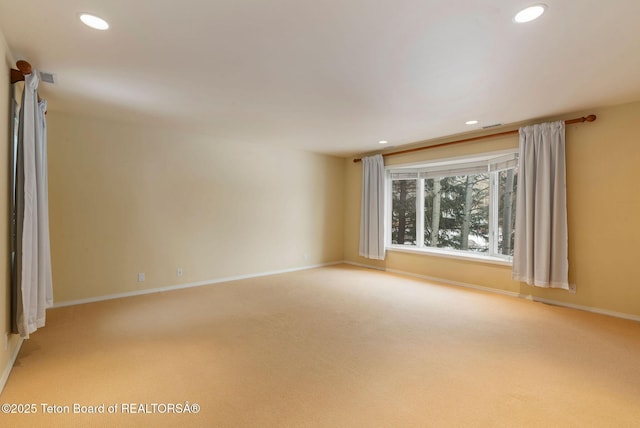 empty room featuring light carpet, visible vents, recessed lighting, and baseboards