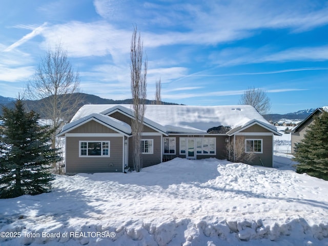 snow covered house featuring an attached garage
