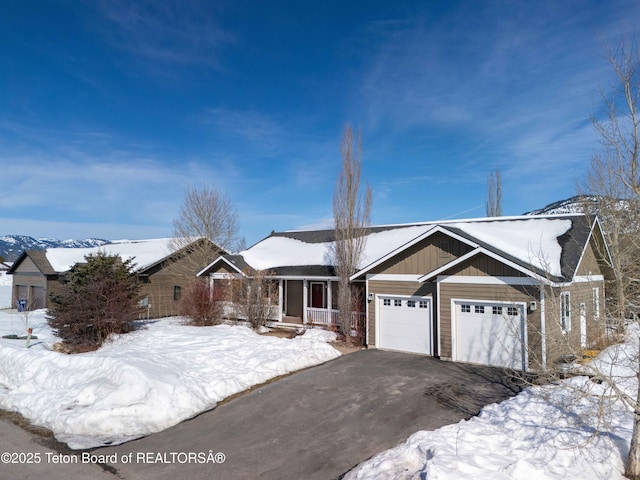 ranch-style home with aphalt driveway, a garage, and board and batten siding
