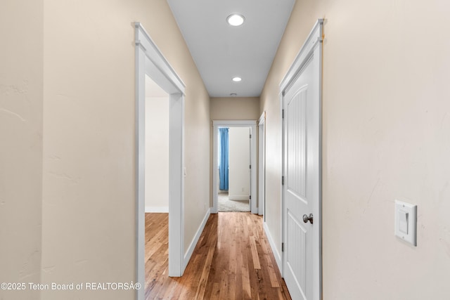 hall featuring recessed lighting, baseboards, and wood finished floors