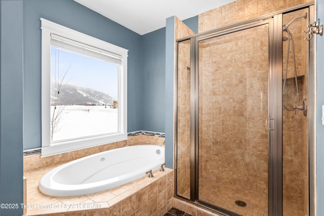full bath with a mountain view, a stall shower, and a bath