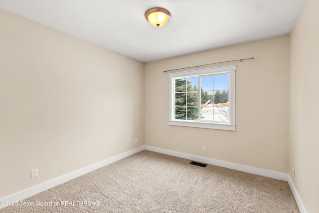 empty room featuring baseboards, visible vents, and carpet floors