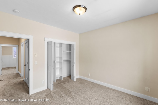 unfurnished bedroom featuring a closet, carpet flooring, and baseboards