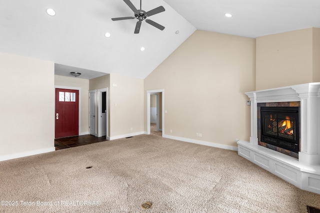 unfurnished living room featuring baseboards, carpet floors, a glass covered fireplace, high vaulted ceiling, and a ceiling fan